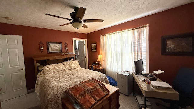 bedroom with carpet floors, a ceiling fan, and a textured ceiling