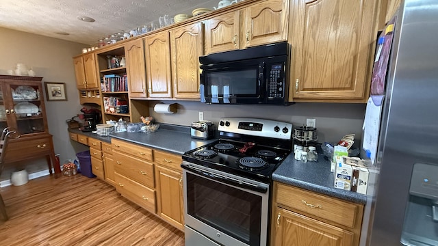 kitchen featuring dark countertops, appliances with stainless steel finishes, a textured ceiling, light wood-type flooring, and open shelves