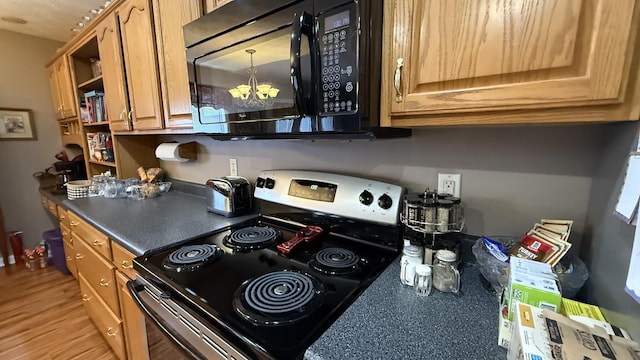 kitchen featuring dark countertops, light wood-style flooring, stainless steel range with electric cooktop, black microwave, and open shelves