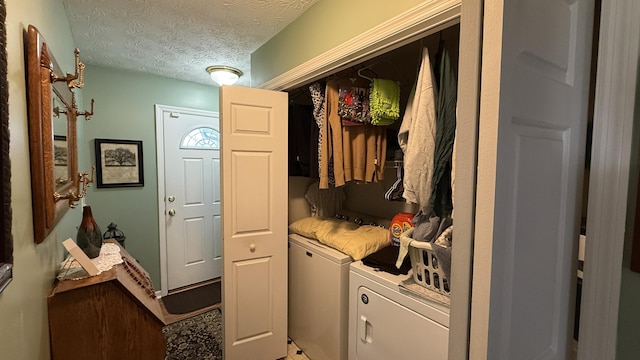 washroom featuring laundry area, separate washer and dryer, and a textured ceiling