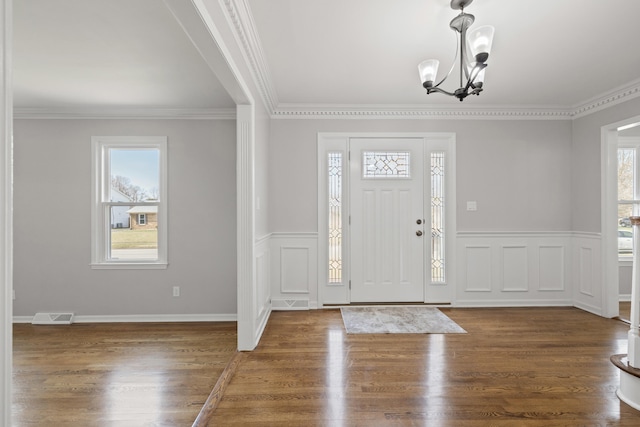 entryway featuring a wealth of natural light, visible vents, an inviting chandelier, and wood finished floors