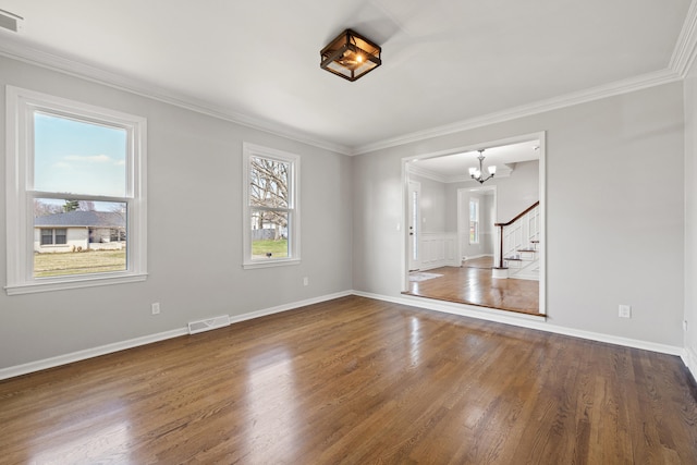 unfurnished room with stairway, wood finished floors, visible vents, crown molding, and a chandelier