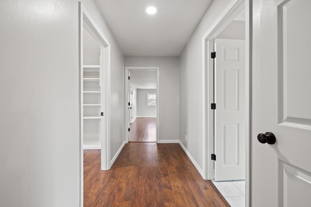 hallway with wood finished floors and baseboards