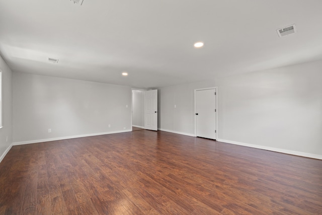 spare room featuring visible vents, recessed lighting, dark wood-type flooring, and baseboards