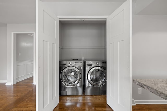 laundry room with laundry area, wainscoting, a decorative wall, and wood finished floors