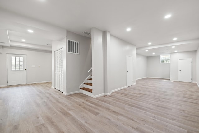 below grade area with light wood-type flooring, stairway, visible vents, and recessed lighting