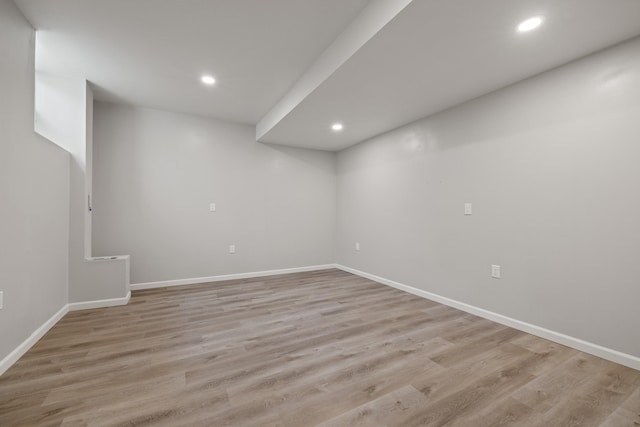 finished below grade area with recessed lighting, light wood-style floors, and baseboards