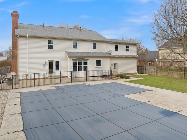 back of house with a patio area, a lawn, a chimney, and a fenced backyard