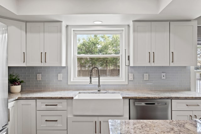 kitchen featuring a sink, dishwasher, and white cabinetry