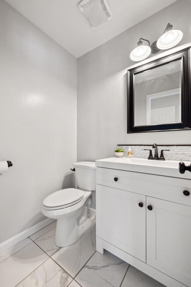 bathroom featuring visible vents, baseboards, toilet, marble finish floor, and vanity