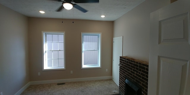 interior space featuring baseboards, visible vents, light colored carpet, ceiling fan, and a textured ceiling