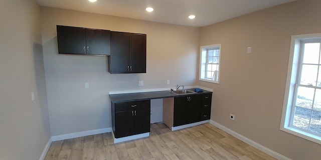 kitchen with a wealth of natural light, baseboards, and a sink