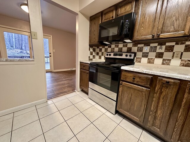 unfurnished living room with ceiling fan, visible vents, baseboards, a brick fireplace, and hardwood / wood-style floors