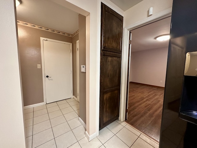 corridor with light tile patterned floors and baseboards