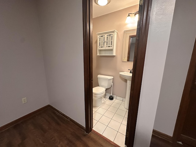 bathroom with tile patterned flooring, a sink, toilet, and baseboards