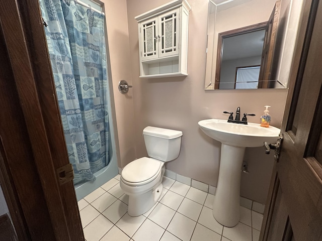 bathroom featuring baseboards, tile patterned flooring, toilet, and a shower with curtain