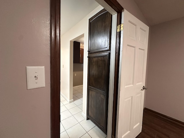 hallway with light tile patterned floors and baseboards