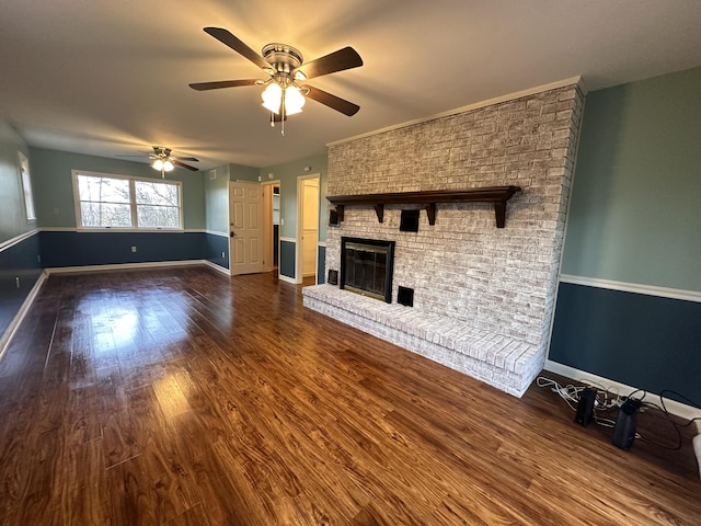 unfurnished living room featuring ceiling fan, a fireplace, wood finished floors, and baseboards