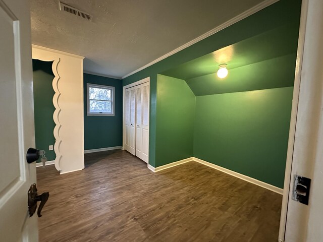 unfurnished bedroom featuring visible vents, a closet, baseboards, and dark wood-type flooring