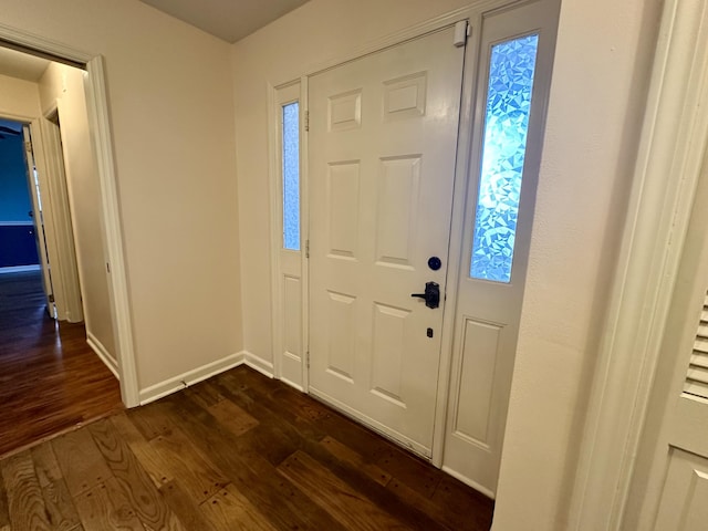 foyer entrance with baseboards and dark wood-style flooring