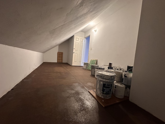 additional living space featuring concrete flooring, lofted ceiling, and a textured ceiling