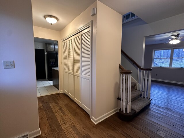 hallway featuring baseboards and dark wood-type flooring