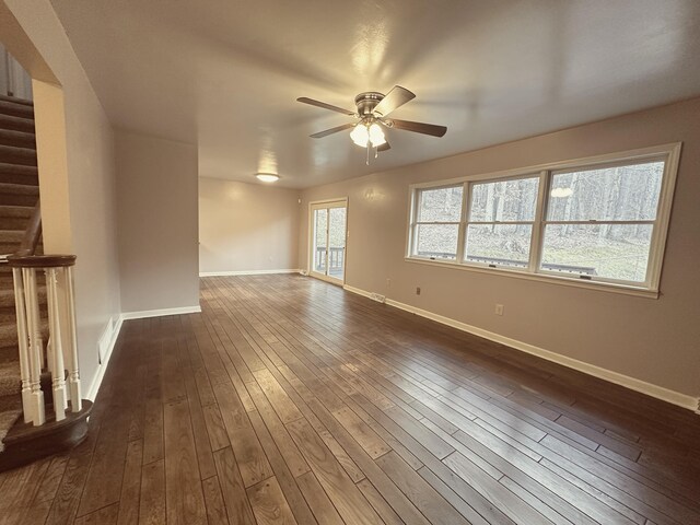 corridor with stairs, dark wood-type flooring, visible vents, and baseboards