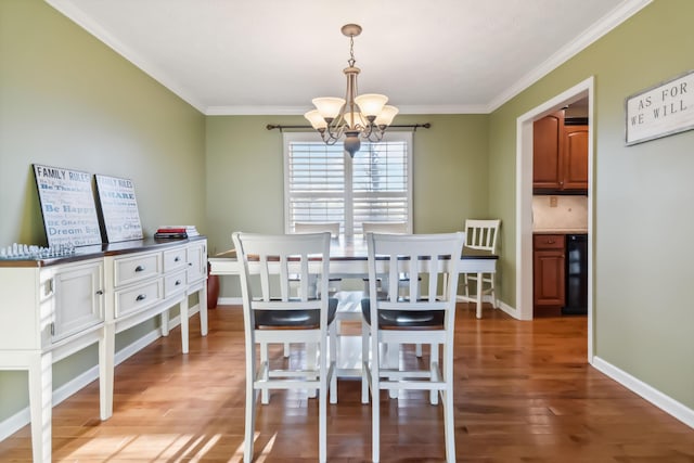 dining space with beverage cooler, wood finished floors, a chandelier, and crown molding