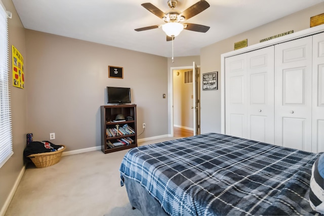 bedroom with a closet, light carpet, ceiling fan, and baseboards