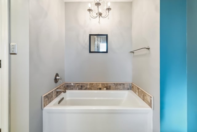 full bath featuring a chandelier and a bath