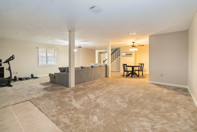 carpeted living area featuring stairway, ceiling fan, visible vents, and baseboards