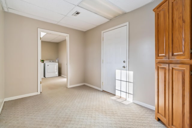 unfurnished room with visible vents, light carpet, washer / dryer, a drop ceiling, and baseboards