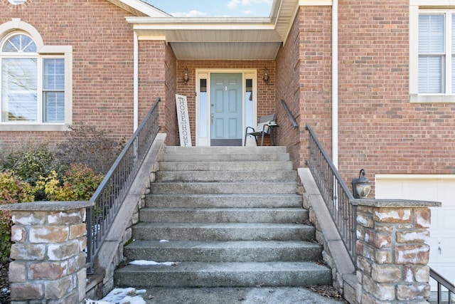 view of exterior entry featuring brick siding