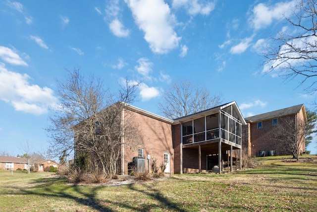 back of house with a yard and a sunroom