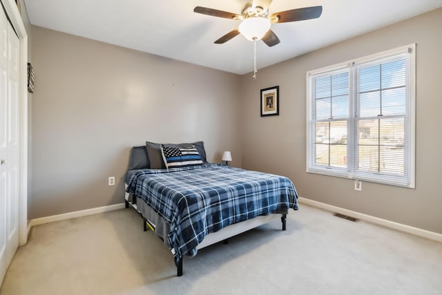 bedroom featuring carpet flooring, a ceiling fan, visible vents, baseboards, and a closet