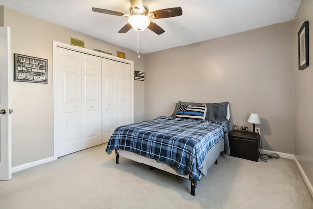 carpeted bedroom with ceiling fan, baseboards, and a closet