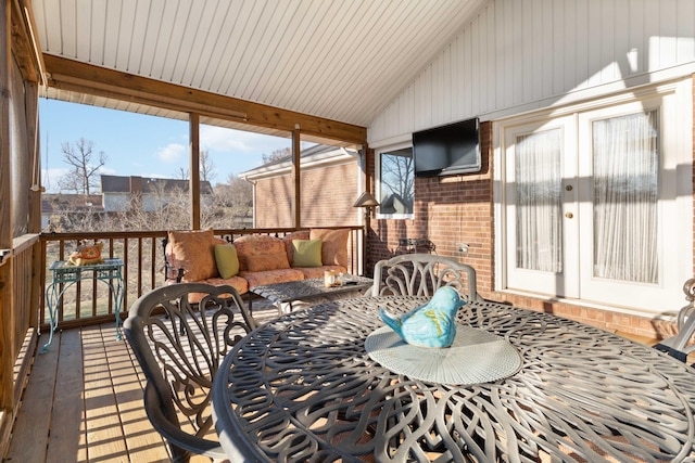 sunroom / solarium featuring vaulted ceiling