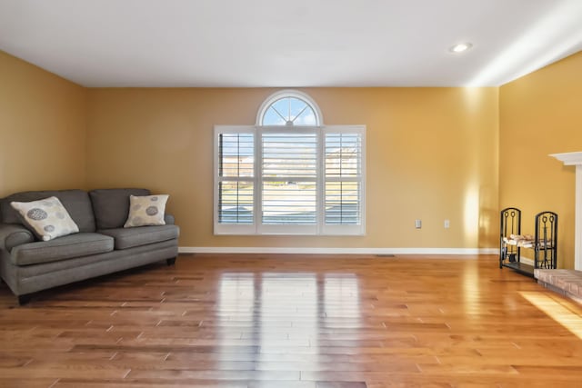 living room with light wood-style floors, baseboards, and recessed lighting