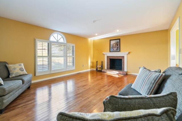 living area with recessed lighting, a fireplace, wood finished floors, and baseboards