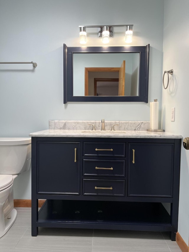 bathroom with vanity, toilet, and baseboards