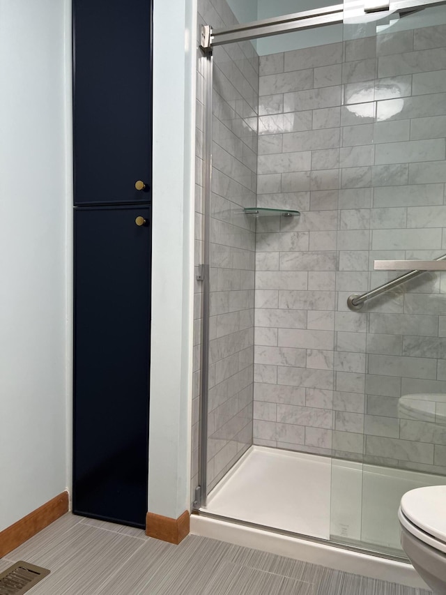 bathroom with toilet, visible vents, baseboards, a shower stall, and tile patterned floors