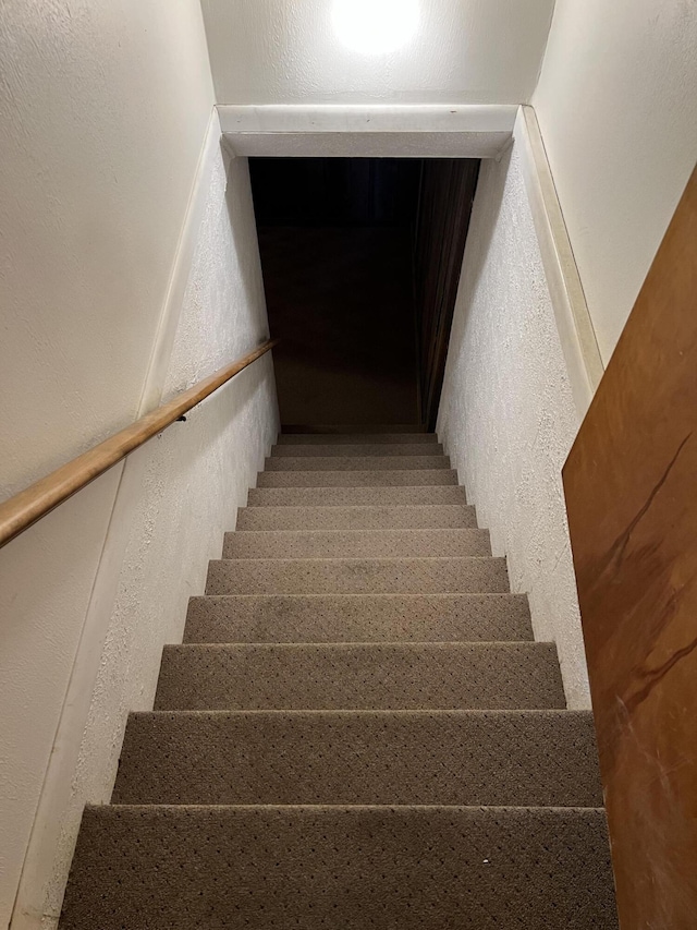 staircase featuring a textured wall