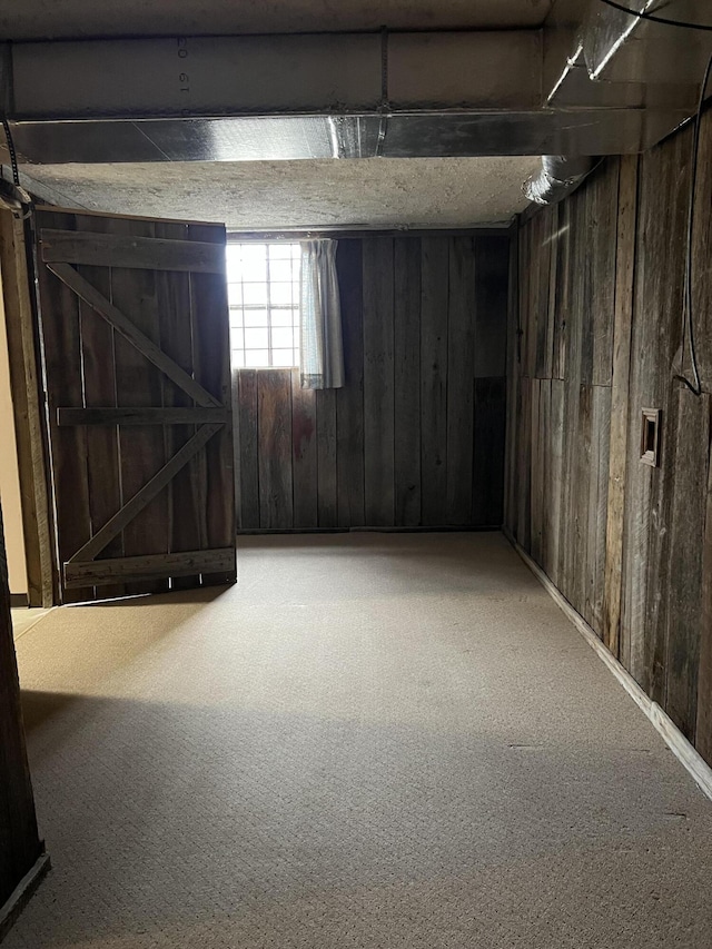 below grade area featuring carpet floors and wood walls