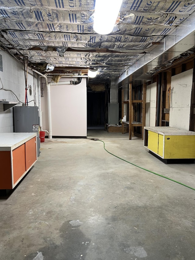 unfinished below grade area featuring concrete block wall and water heater