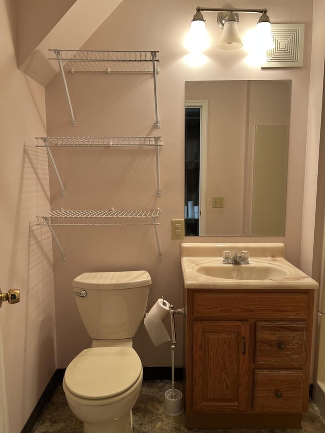 bathroom with baseboards, vanity, and toilet