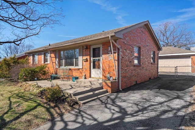 ranch-style house featuring crawl space, a detached garage, and brick siding