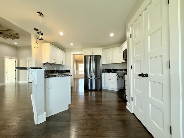 kitchen with dark wood-style floors, black gas stove, freestanding refrigerator, and recessed lighting