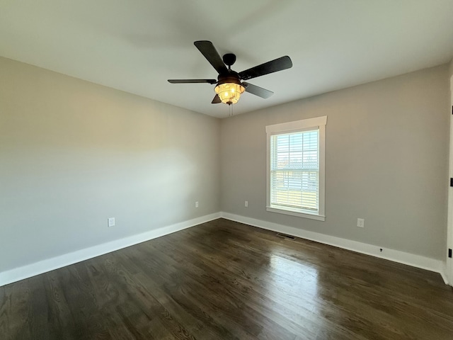 unfurnished room featuring ceiling fan, visible vents, baseboards, and dark wood-type flooring