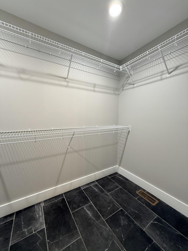 spacious closet with marble finish floor and visible vents