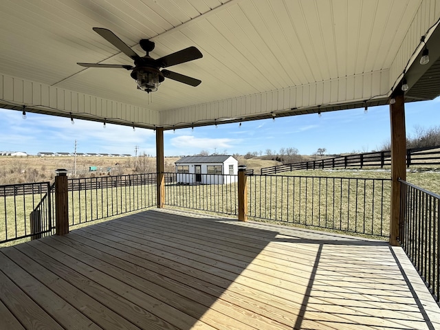 wooden terrace with a ceiling fan, an outbuilding, and a storage unit